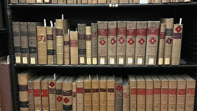 Shelves full of old law books with brown leather spines and small library labels.